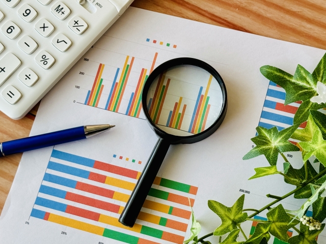 グラフが描かれた紙と虫眼鏡