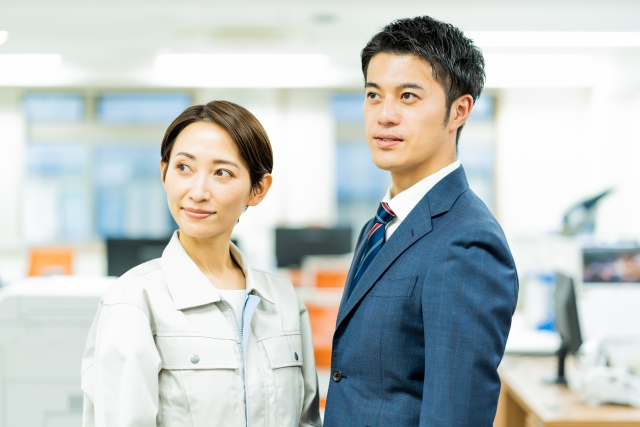 スーツを着た男性と作業着を着た女性