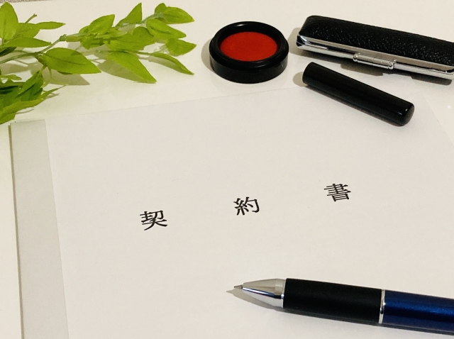 契約書と印鑑・ペンが並ぶ署名準備の場面