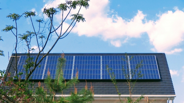 戸建住宅の屋根に設置された太陽光発電パネルと青空